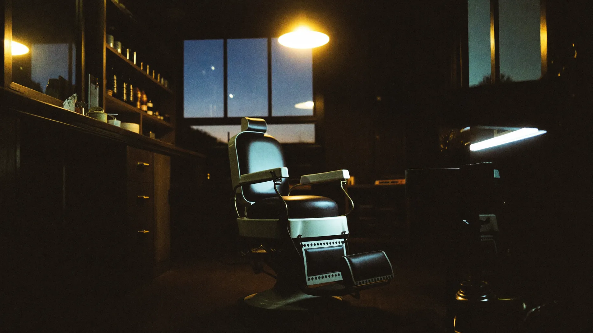 Cadeira de barbeiro vintage sob luz âmbar na Barbearia Vieira